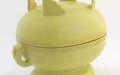 A Chinese yellow ground lidded pot raised on a foot