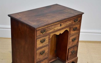 A George III mahogany knee-hole desk with an arrangement of...