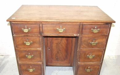 A George III mahogany kneehole desk fitted with nine small d...