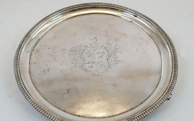 A George III silver salver, London, 1817, Joseph Craddock & William Ker Reid, designed with gadrooned rim and raised on three bracket feet, armorial engraved to centre, 25.7cm dia., approx. weight 17.5oz