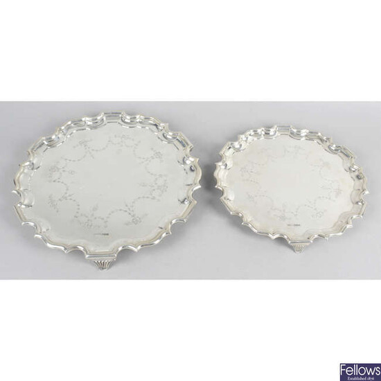 A George V silver salver with engraved swag motifs, together with a matching smaller example. (2).