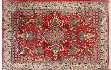 A PERSIAN ISFAHAN CARPET, red ground with central
