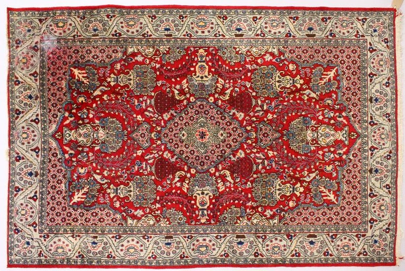 A PERSIAN ISFAHAN CARPET, red ground with central