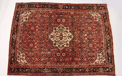 A PERSIAN RUG, 20TH CENTURY, red ground with central