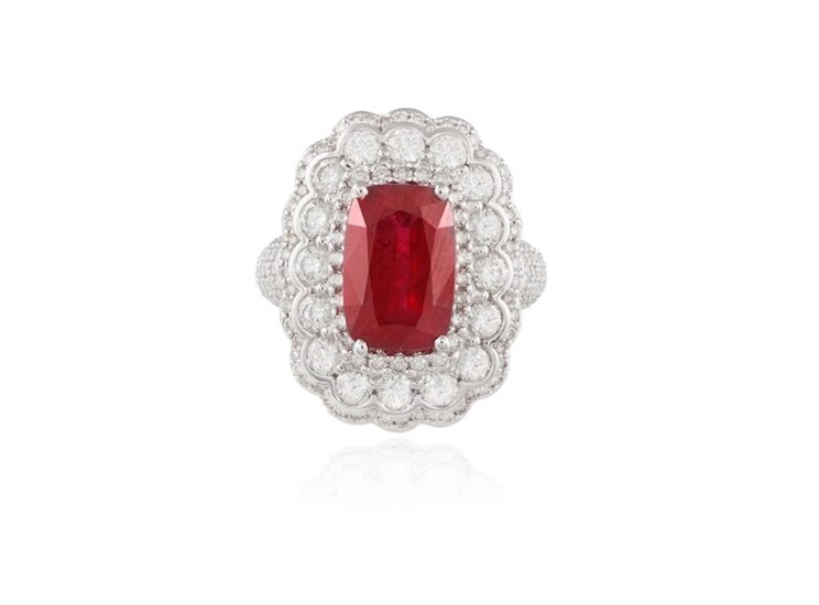 A RUBY AND DIAMOND DRESS RING The elongated cushion-shaped ruby...