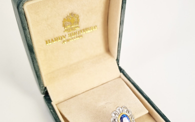 A SAPPHIRE AND DIAMOND BORDER DRESS RING: palish oval sapphire (8
