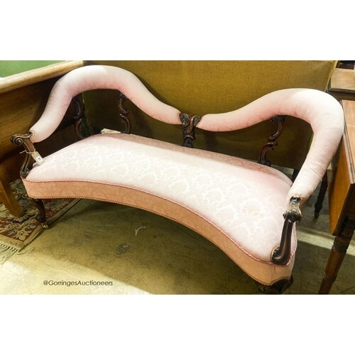 A Victorian walnut love seat, upholstered in floral damask, ...