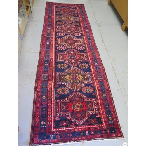 A blue and red ground hand woven runner with a cross door de...