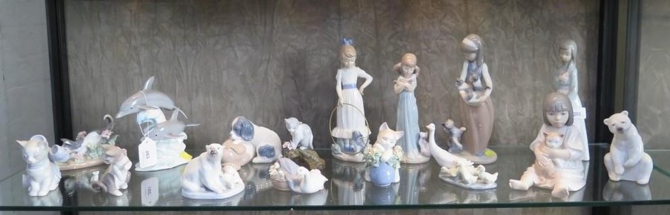 A collection of Lladro and Nao figures of children, polar be...
