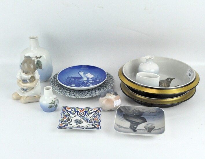 A collection of Royal Copenhagen ceramics, including floral vases, figures of birds and a child