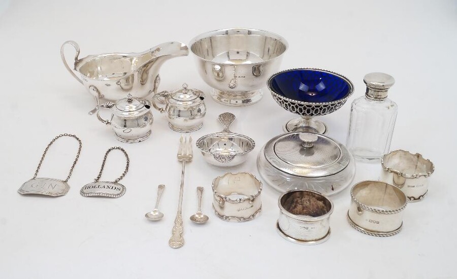 A group of silver, to include: a George III decanter label, with pierced HOLLANDS to centre, no city mark, 1807, Thomas Phipps & Edward Robinson; a decanter label, Birmingham, 1985, J B Chatterley & Sons Ltd, marked GIN; a footed bowl, with London...