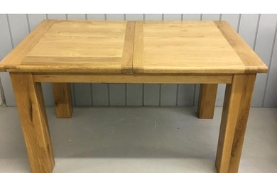 A high-quality, solid light oak extending dining table, in a...