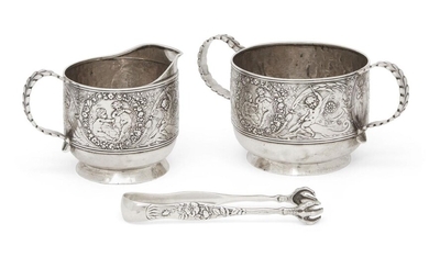 A late 19th century Tiffany & Co. cream jug, sugar and tongs, c.1890, each stamped sterling, the sugar and jug decorated with scenes of winged putti riding dolphins and playing musical instruments, both designed with shaped foliate handles, the...