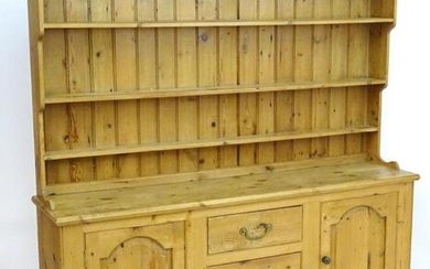 A mid 20thC pine dresser with a moulded cornice above