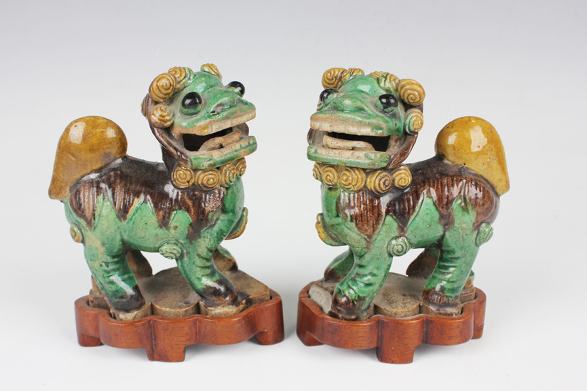 A pair of Chinese sancai enamelled biscuit porcelain figures of Buddhistic lion dogs, Kangxi period