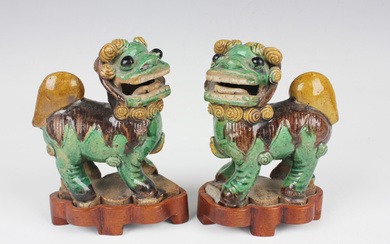 A pair of Chinese sancai enamelled biscuit porcelain figures of Buddhistic lion dogs, Kangxi period