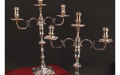 A pair of George II cast silver table candlesticks, fitted w...