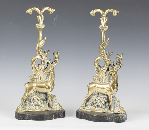 A pair of Victorian cast brass and iron doorstops, modelled as stags below a scrolling terminal, hei