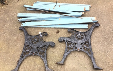 A pair of cast iron bench ends with scrolled arms...