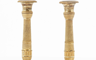 A pair of gilt bronze candlesticks, France, first half of the 19th century, empire, fluted shaft, stylized leaf border, mountain decor, foot with palmette border.