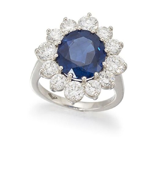 A sapphire and diamond cluster ring, the central...