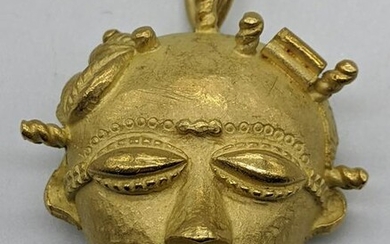 An 18ct gold African mask pendant/brooch, marks for