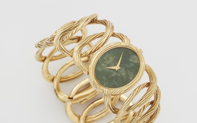 An 18k yellow gold and mottled green nephrite jade ladies' Piaget cuff wristwatch retailed by Cartier.