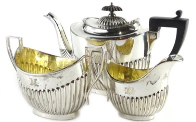 An Edwardian silver three piece tea set, each with...