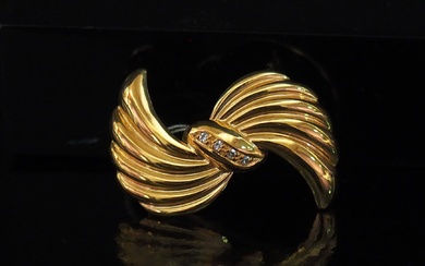 Broche en forme de nœud godronné en or jaune 750, sertie en son centre d'une...