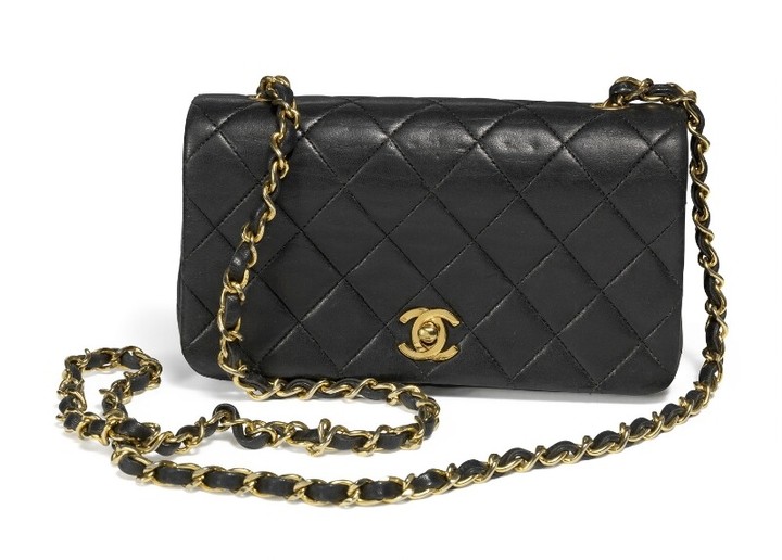 Chanel: A mini "Flap bag of black quilted lampskin with golden hardware and chain strap with one intererior compartment with two pockets.