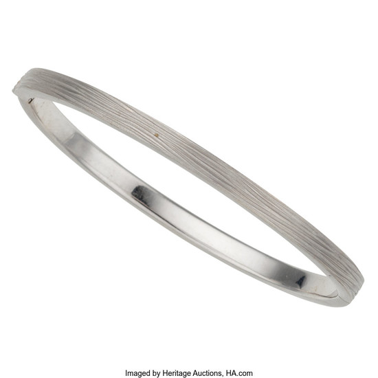 Diamond, White Gold Bracelet The hinged bangle features a...