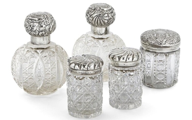Five silver mounted glass vanity vessels, including: a pair of globular cut glass examples, London, probably c.1900, Charles Fox & Co., (marks rubbed), both with cut glass stoppers and repousse decorated screw caps, 14.3cm high; a pair of Victorian...