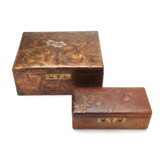 Two art noveau leather boxes with embossed flowers, partly coloured one box gilt. C. 1900. L. 25,5–33 cm. H. 8–13 cm. D. 13–27 cm. (2)