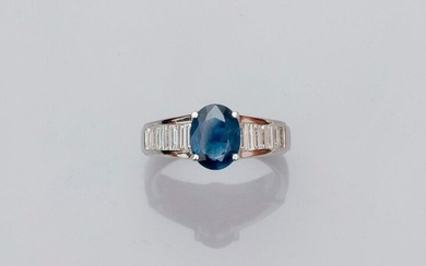 White gold ring, 750 MM, set with an oval sapphire weighing 2.01 carats between two lines of baguette-cut diamonds, total about 1 carat, size: 54, weight: 6.6gr. rough.