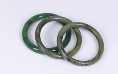 Three bangles, including two "spinach jade" examples and...