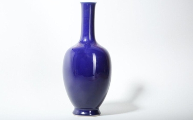 A CHINESE BLUE-GLAZED BOTTLE VASE. With an ovoid body and a tall cylindrical neck decorated with a deep cobalt-blue glaze, all raised on a splayed foot, the interior and underside glazed white, 28.5cm H. 藍釉長頸撇口瓶