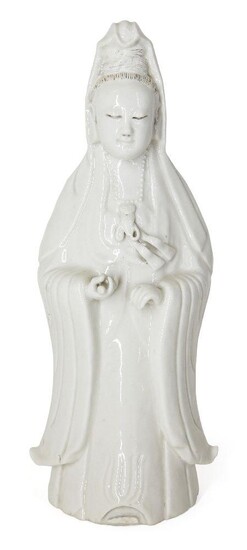 A Chinese Dehua porcelain figure of Guanyin, 19th century, modelled standing with long flowing robes, her right hand holding a scroll, 32.8cm high