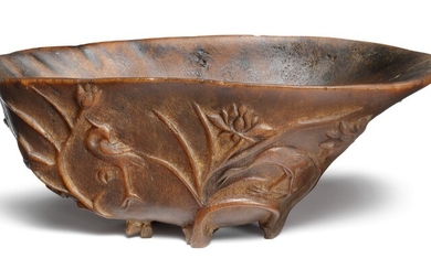 A Chinese carved libation rhinoceros cup carved with lotus in bloom. 18th century. Weight 217 g. H. 6 cm L. 17 cm. B. 9.5 cm.