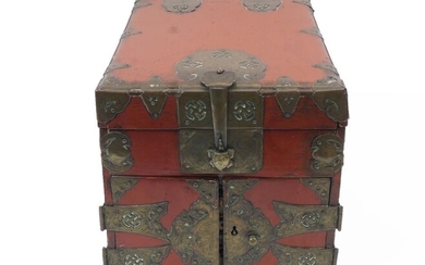 A Chinese red lacquer and brass mounted table top seal chest, early 20th century, the brass mounts with Wan symbols, with hinged lid to top above two doors to one end enclosing two small drawers, 24.5cm high, 23cm wide, 33cm deep