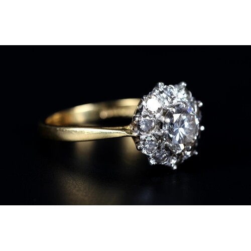 A DIAMOND CLUSTER RING in 18ct yellow and white gold, claw s...