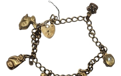 A VINTAGE 9CT GOLD CHARM BRACELET Set with six charms and he...