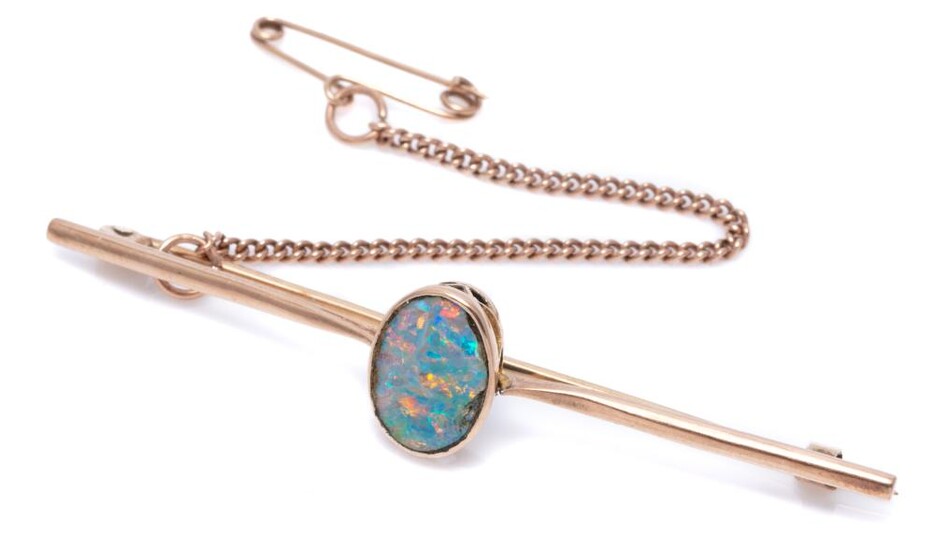A VINTAGE 9CT ROSE GOLD OPAL BAR BROOCH; centring a rub set opal doublet (chipped around edges, between tapered upswept shoulders, s...