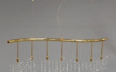 A brass Swarovski ceiling light, of recent manufacture, of curved form with seven pendant lights and cut glass crystal droplets, 100cm high, 116cm wide It is the buyer's responsibility to ensure that electrical items are professionally rewired for...