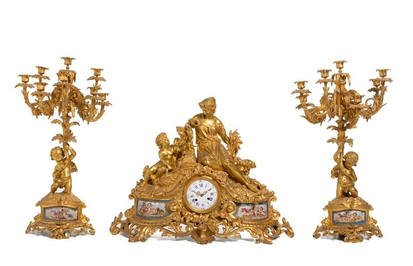 A gilt-bronze and porcelain mantel clock and candelabra