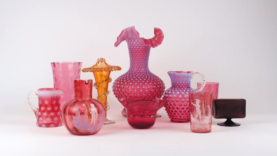 A group of cranberry glass, 20th century, to include a large bulbous textured vase with handkerchief rim, 27cm high, a similar textured jug, a bulbous jug with painted decoration of a young boy, and various other pieces, together with an orange...