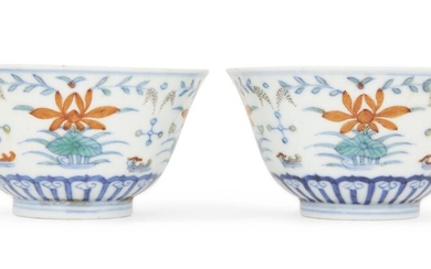 A pair of Chinese porcelain doucai 'duck and lotus' bowls, Ai lian zhen shang marks, Daoguang period, each bowl painted to the exterior with two pairs of mandarin ducks swimming amongst four large lotus blooms and reeds above a band of upright...