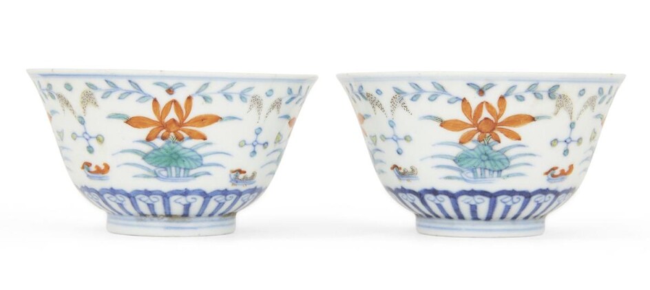 A pair of Chinese porcelain doucai 'duck and lotus' bowls, Ai lian zhen shang marks, Daoguang period, each bowl painted to the exterior with two pairs of mandarin ducks swimming amongst four large lotus blooms and reeds above a band of upright...