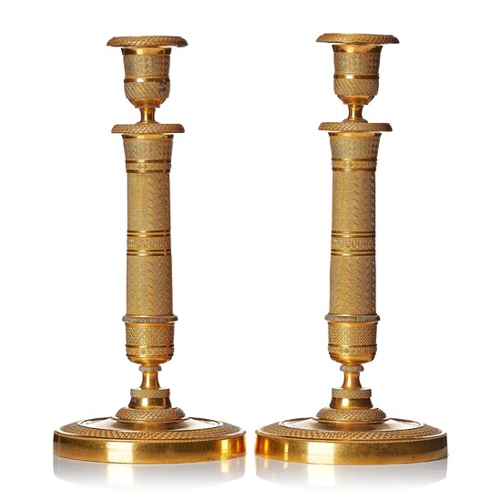 A pair of French gilded Empire candlesticks.