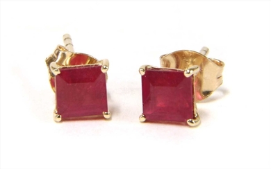 A pair of gold single stone treated ruby stud earrings