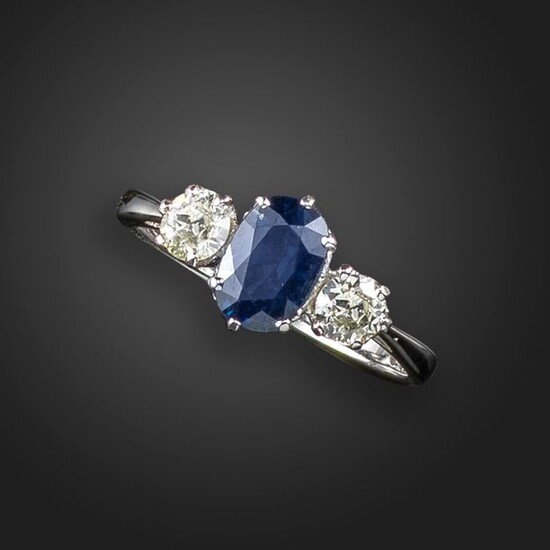 A sapphire and diamond three-stone ring, the oval-shaped sapphire set...